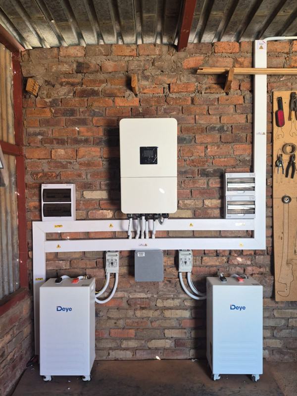 Deye hybrid inverter and two Deye battery cabinets, with a busbar box and fused isolators.